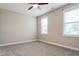 Well-lit bedroom with plush carpet, neutral paint, and windows providing natural light at 67 Bornean Dr, Garner, NC 27529