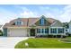 Inviting two-story home featuring a well-manicured lawn and a two-car garage with stone detailing at 67 Bornean Dr, Garner, NC 27529