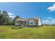 View of the backyard with a covered patio, flower beds, and well-maintained lawn on a sunny day at 7055 Nc-242, Dunn, NC 28334