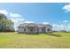 Backyard view features a covered patio, lush lawn, flower beds, and ample space for outdoor activities at 7055 Nc-242, Dunn, NC 28334