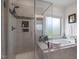 This bathroom showcases a luxurious soaking tub, a glass-enclosed shower, and stylish tile accents at 7055 Nc-242, Dunn, NC 28334