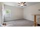 Bright bedroom featuring neutral walls, carpet, ceiling fan and a sunlit window at 7055 Nc-242, Dunn, NC 28334