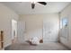 A bright bedroom featuring neutral walls, carpet, ceiling fan, closet, and a sunlit window at 7055 Nc-242, Dunn, NC 28334