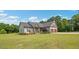 An eye-level view of the exterior of the home featuring a two-car garage and manicured lawn at 7055 Nc-242, Dunn, NC 28334