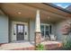 Close up of porch shows decorative pillars, seating area and glass paned front door at 7055 Nc-242, Dunn, NC 28334