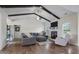 Comfortable living room features a fireplace, vaulted ceiling with wooden beams, and a large sofa at 7055 Nc-242, Dunn, NC 28334
