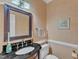 Half bath features a vanity with a black countertop and a framed mirror at 7613 Percy Ct, Raleigh, NC 27613
