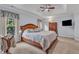 Main bedroom with tray ceiling, ceiling fan, and a large window offering natural light at 7613 Percy Ct, Raleigh, NC 27613
