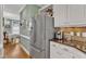Stainless steel refrigerator in kitchen next to granite countertop and cabinets at 7613 Percy Ct, Raleigh, NC 27613