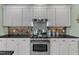 Close up of the gas stove, hood, and cabinets in this updated kitchen with granite countertops at 7613 Percy Ct, Raleigh, NC 27613