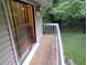 A wooden balcony overlooks a green lawn, accessible through a sliding glass door at 875 Mlk Jr Boulevard,15, Chapel Hill, NC 27514