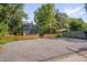 Rear view of the home with ample parking, a fenced in yard, and gravel driveway at 924 W Trinity Ave, Durham, NC 27701
