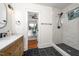 Bathroom view featuring a marble tiled walk-in shower, sink vanity, and a glimpse into an office space at 924 W Trinity Ave, Durham, NC 27701