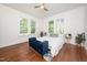 Bright bedroom features a bed, blue bench, and large windows with views of mature trees at 924 W Trinity Ave, Durham, NC 27701