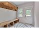 Cozy mudroom with built-in bench, coat hooks, and stylish patterned floor tiles at 924 W Trinity Ave, Durham, NC 27701