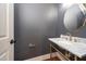 Chic powder room featuring a marble vanity with gold fixtures, and a stylish oval mirror at 924 W Trinity Ave, Durham, NC 27701