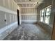 Unfinished living room showcasing large windows, a door, and unfinished walls at 1025 Coldspring Circle, Durham, NC 27705