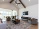 Bright living room with vaulted ceilings, wooden beams, large rug, and an open layout with large windows at 1025 Coldspring Circle, Durham, NC 27705