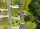 An aerial view of a home in a quaint neighborhood with mature trees, a deck, and a beautiful lawn at 106 Oak Rd, Butner, NC 27509