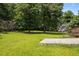 Beautiful backyard with green grass, mature trees, and a concrete patio at 106 Oak Rd, Butner, NC 27509