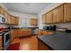 Functional kitchen with wood cabinets, stainless steel dishwasher, and dark countertops at 106 Oak Rd, Butner, NC 27509