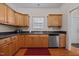 Efficient kitchen with wood cabinets, stainless steel dishwasher, and black countertops at 106 Oak Rd, Butner, NC 27509