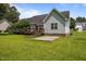 Rear exterior of single Gathering home showing manicured lawn, small deck, and room for backyard lounging at 106 Oak Rd, Butner, NC 27509