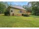 Exterior view of home featuring a wooden deck and expansive green lawn at 109 Springwood Dr, Wake Forest, NC 27587