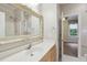 Bathroom features a vanity with a large decorative mirror, white countertops, and a shower-tub combo at 109 Springwood Dr, Wake Forest, NC 27587