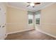 Sunlit bedroom features wood-look floors, neutral walls, white trim, and windows with valances at 109 Springwood Dr, Wake Forest, NC 27587