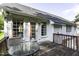 Back deck with weathered planks, glass table and seating, and access to the house through french doors at 1112 Newberry Dr, Mebane, NC 27302