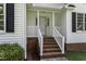 Inviting front porch with brick steps and white railing, offering a warm welcome at 1112 Newberry Dr, Mebane, NC 27302