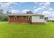 Exterior view of the home with brick and white siding, showing a well-maintained lawn and mature trees at 1209 Bobbitt Dr, Garner, NC 27529