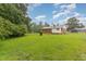 Exterior shot showcases a well-maintained yard with a mix of green grass and mature shade trees around property at 1209 Bobbitt Dr, Garner, NC 27529