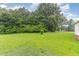 View of the home's backyard features lush green grass and mature trees, perfect for outdoor activities at 1209 Bobbitt Dr, Garner, NC 27529