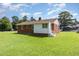 View of the backyard of the brick home with a well-maintained lawn, and a combination of brick and white siding at 1209 Bobbitt Dr, Garner, NC 27529