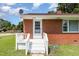 Close-up of the home's entrance featuring a white door, stairs, and a vibrant red brick facade at 1209 Bobbitt Dr, Garner, NC 27529