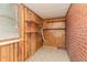 Small laundry room with linoleum flooring, wood paneling, brick accents, built-in shelves, and a utility sink at 1209 Bobbitt Dr, Garner, NC 27529