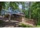 Blue contemporary home nestled among trees, featuring a spacious deck and a fenced yard at 123 Becket Bend Bnd, Pittsboro, NC 27312