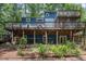 Unique blue home with multiple decks and lush landscaping creating a serene outdoor oasis at 123 Becket Bend Bnd, Pittsboro, NC 27312