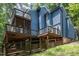 View of the back of a modern home with multiple decks and backyard wood fence at 123 Becket Bend Bnd, Pittsboro, NC 27312