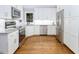 Modern kitchen with stainless steel appliances, granite countertops, white cabinets, and hardwood flooring at 123 Becket Bend Bnd, Pittsboro, NC 27312