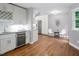 Kitchen and seating area with wine cooler, stainless refrigerator, white cabinets and hardwood floors at 123 Becket Bend Bnd, Pittsboro, NC 27312