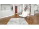 Bright living room with wood floors, a modern white chair, and staircase with wooden handrail at 123 Becket Bend Bnd, Pittsboro, NC 27312