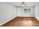 This large living room features hardwood floors, a ceiling fan, and natural light from a large window at 1311 Meadow Ln, Chapel Hill, NC 27516