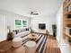 Bright, staged living room with wood floors, comfortable seating, and ample natural light at 1311 Meadow Ln, Chapel Hill, NC 27516