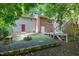 Backyard with brick and vinyl siding, featuring a fire pit, mature trees, and a wooden deck with stairs at 1416 Bramble Dr, Durham, NC 27712
