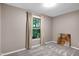 Bedroom featuring neutral paint, carpet, and curtains framing a window with wooded exterior view at 1416 Bramble Dr, Durham, NC 27712