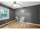 Gray bedroom with wood floors, modern lighting, window with bright, natural light and artwork at 1416 Bramble Dr, Durham, NC 27712
