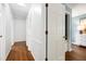 Bright hallway featuring hardwood floors, neutral paint, and white doors with classic hardware at 1416 Bramble Dr, Durham, NC 27712